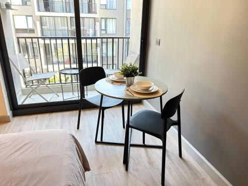 El CerrilloにあるDiseño y conectividad, tu espacio en Santiagoのバルコニー付きの客室で、テーブルと椅子が備わります。