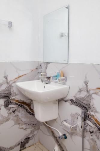 a white bathroom with a sink and a mirror at The Green Rest in Waskaduwa