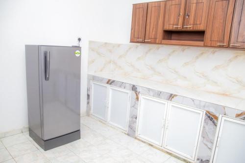 a stainless steel refrigerator in a kitchen with windows at The Green Rest in Waskaduwa