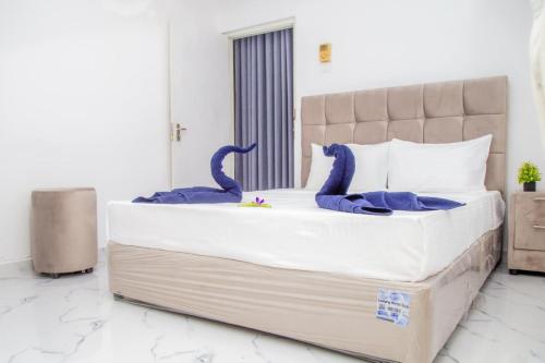 a bedroom with a large bed with blue dinosaur pillows at The Green Rest in Waskaduwa