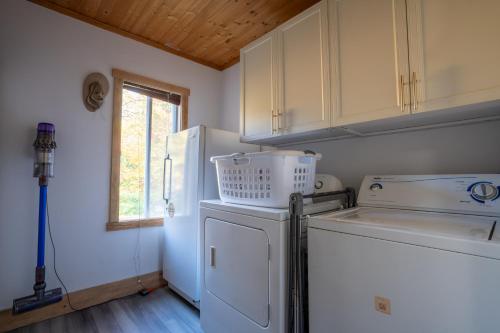 彻特西Cozy Riverside Chalet SPA Fireplace Nature Escape的厨房配有洗衣机和烘干机以及窗户。