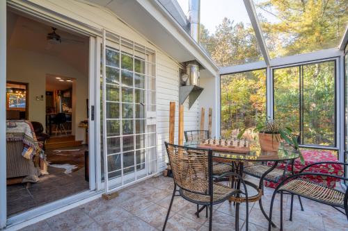 彻特西Cozy Riverside Chalet SPA Fireplace Nature Escape的带桌椅的封闭式门廊