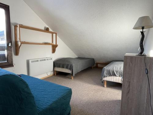 Saint-AventinSuperbagneres appartement au pied des pistes的一间卧室配有一张床和一张搁脚凳