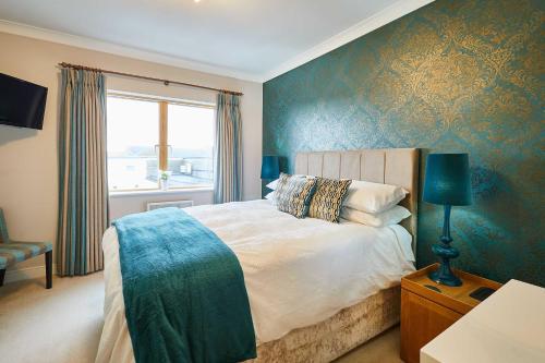 a bedroom with a large bed and a window at Host & Stay - The Shipshape in Seahouses