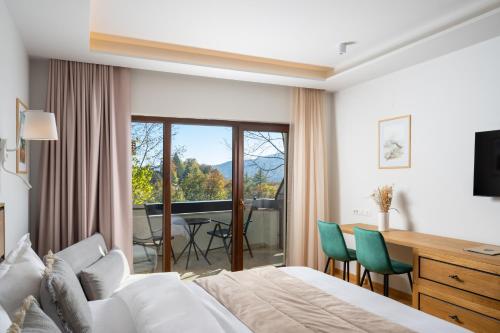 a hotel room with a bed and a desk and a balcony at Pensiunea Leonida - RESORT LEONIDA in Poiana Ţapului