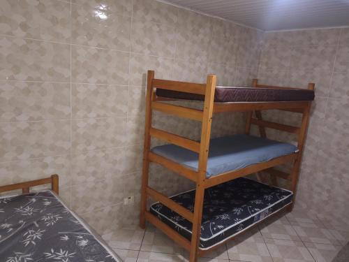 Casa na Praia في برايا جراندي: غرفة بها سرير بطابقين ورف خشبي