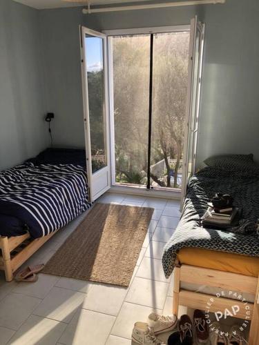 une chambre avec un lit et une grande fenêtre dans l'établissement Maison Collobrières, à Collobrières