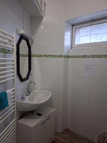 Lignières-de-TouraineにあるAu Cœur de Lignièresの洗面台と鏡のある白いバスルーム