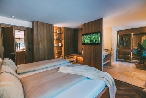 een slaapkamer met een groot bed en houten wanden bij Residence Alpi - Private Spa & Living in Grainau