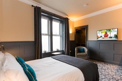 a hotel room with a bed and a tv at Irvine Guest House in Irvine