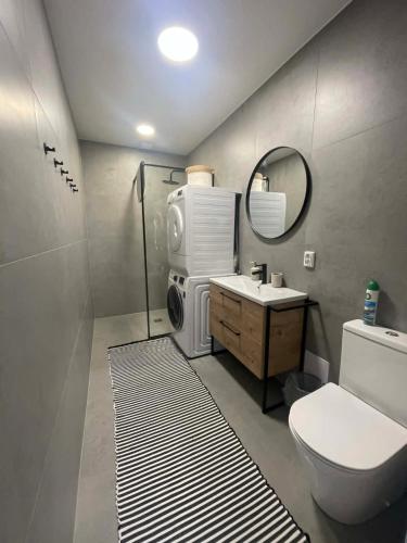 a bathroom with a toilet sink and a washing machine at Cozy House By VP in Anykščiai