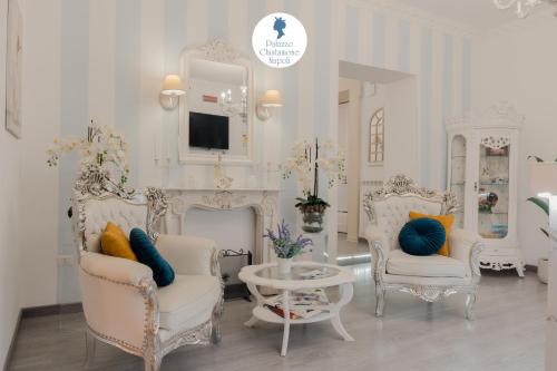 un soggiorno con due sedie e un camino di Palazzo Chiatamone a Napoli