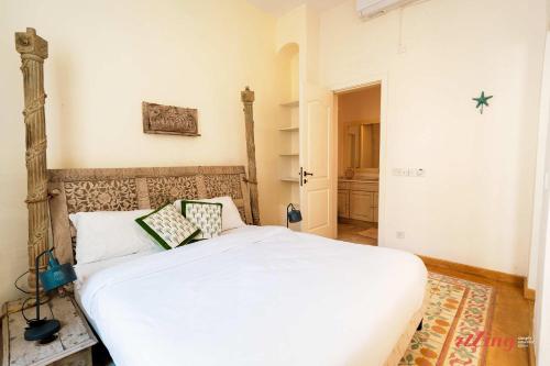 een slaapkamer met een wit bed met kussens erop bij Stunning Holiday Home with Gorgeous Harbour Views in Senglea