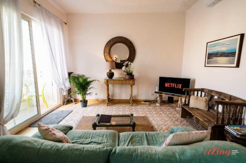 a living room with a green couch and a mirror at Stunning Holiday Home with Gorgeous Harbour Views in Senglea