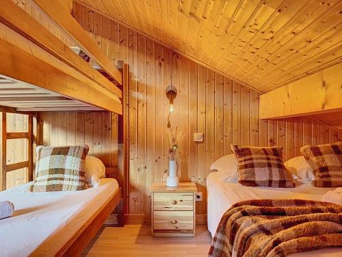 モントリオンにあるChalet Altaïa - Morzine Avoriaz - 12 Personnes - Billard & Jeux vidéo - Parking & Garageの木製の壁の部屋にベッドが2つある