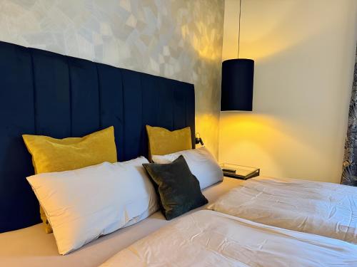 a bedroom with two beds and yellow pillows at Zeitloser Luxus am Wasserschloss in Neukirchen