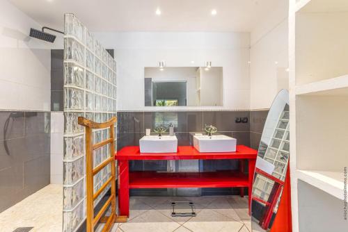 Oyster PondVilla Taïana的浴室设有两个盥洗盆和红色的柜台。