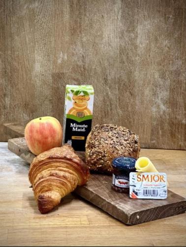a table with a cutting board with food and an apple at Day Dream Soleyjargata Rooms & Apartments in Reykjavík
