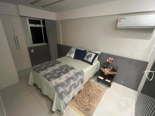 mała sypialnia z łóżkiem i stołem w obiekcie Melhor Apto no Centro ao lado da Praia e Comércio w mieście Guarapari