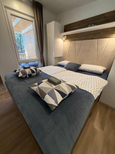 een slaapkamer met twee bedden en een groot raam bij Mobile Home LOREN in Biograd na Moru