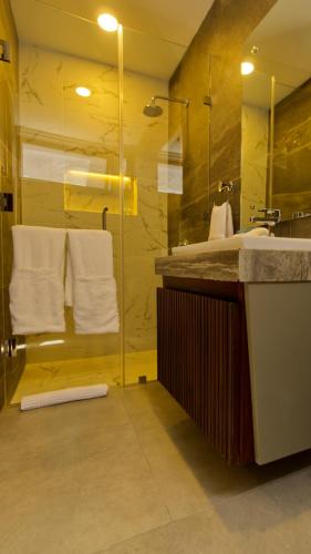 a bathroom with a sink and a shower with towels at Hotel Tiffany in Flores