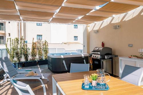 a patio with a heater and a table and chairs at Stunning 4BR Villa with Heated Jacuzzi in St Paul's Bay in St. Paul's Bay