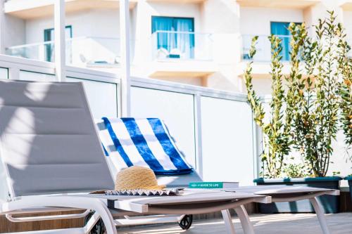 un cappello di paglia seduto su una sedia sul balcone di Stunning Holiday Villa with a Heated Jacuzzi a San Pawl il-Baħar