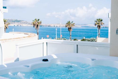 a bath tub with a view of the ocean at Stunning 4BR Villa with Heated Jacuzzi in St Paul's Bay in St. Paul's Bay