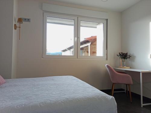 a bedroom with a bed and a desk and a window at Abril 56 Villa&Suites in Oreña