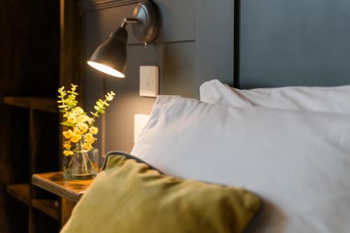 a bedroom with a bed with a lamp and a pillow at Irvine Guest House in Irvine