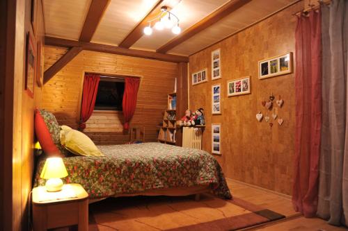 1 dormitorio con 1 cama en una habitación de madera en Couleurs Nature, en Thanvillé
