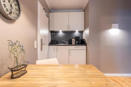 een keuken en eetkamer met een houten tafel bij Logierhaus K15 Appartement 1 in Borkum