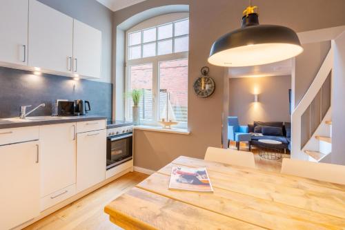 een keuken en een woonkamer met een tafel en een eetkamer bij Logierhaus K15 Appartement 2 Plus in Borkum