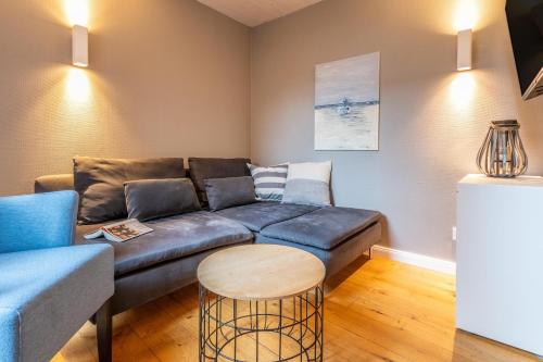 een woonkamer met een bank en een tafel bij Logierhaus K15 Appartement 2 Plus in Borkum