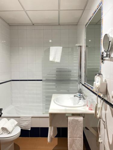a bathroom with a sink and a tub and a toilet at Hotel San Julian in Burunchel