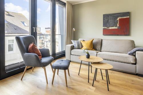 een woonkamer met een bank en twee stoelen bij InselLoft Wohnung 4 in Borkum