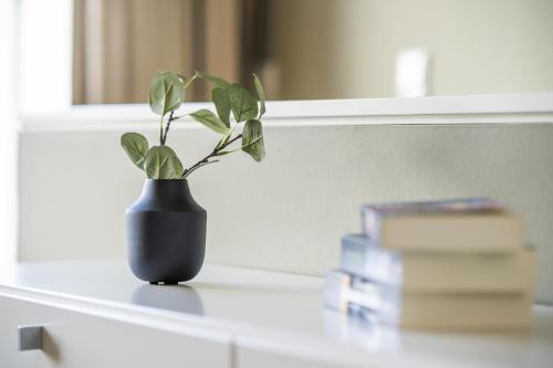 een plant in een vaas op een tafel met boeken bij InselLoft Wohnung 4 in Borkum