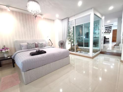 a white bedroom with a bed and a large window at Home Base at Krabi in Ban Khlong Chi Lat