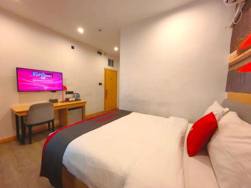 a bedroom with a bed and a desk and a tv at Ivy Hotel Aromire in Hausa