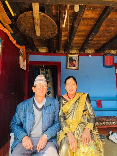 two people sitting on a chair in a room at Thir bahadur karki's Home 