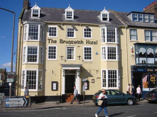 a building on a street with people walking in front of it at The Brunswick Hotel in Bridlington