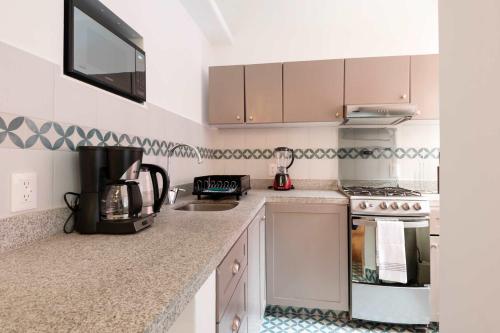 a kitchen with white cabinets and a counter top at Breezy 2BR in Polanco in Mexico City