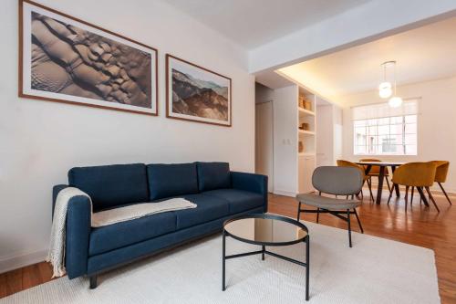 a living room with a blue couch and a table at Breezy 2BR in Polanco in Mexico City