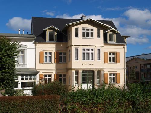 a white building with a black roof at Brise Villa Emmi App 04 in Heringsdorf