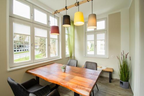 a dining room with a wooden table and chairs at Brise Villa Emmi App 04 in Heringsdorf