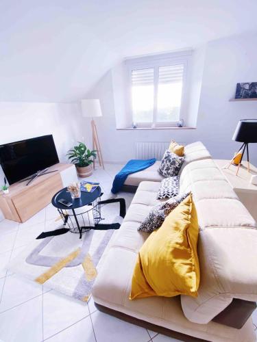 a living room with a couch and a table at Appartement au calme - T3, Ancenis, A11 in Mésanger