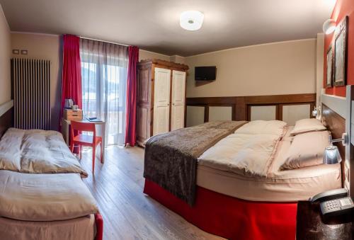 ein Hotelzimmer mit zwei Betten und einem Fenster in der Unterkunft Hotel Lyskamm in Breuil-Cervinia