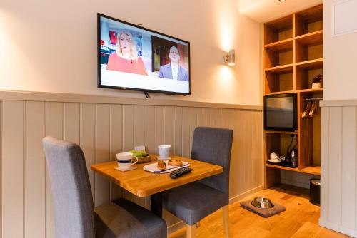 a dining room with a table and a tv on the wall at Irvine Bay in Irvine