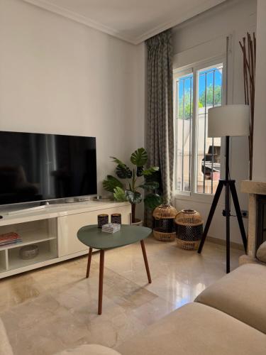 a living room with a tv and a table at Casa Dos Palomas in Bahia de Casares