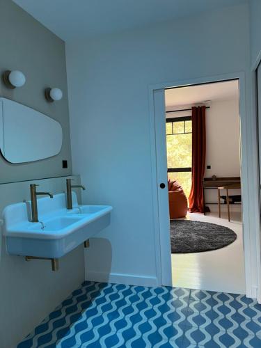 a blue bathroom with a sink and a mirror at Villa Lombardière in Gujan-Mestras